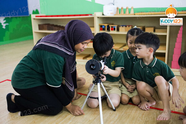 Teacher guiding preschool children during personalised learning session in Kulai